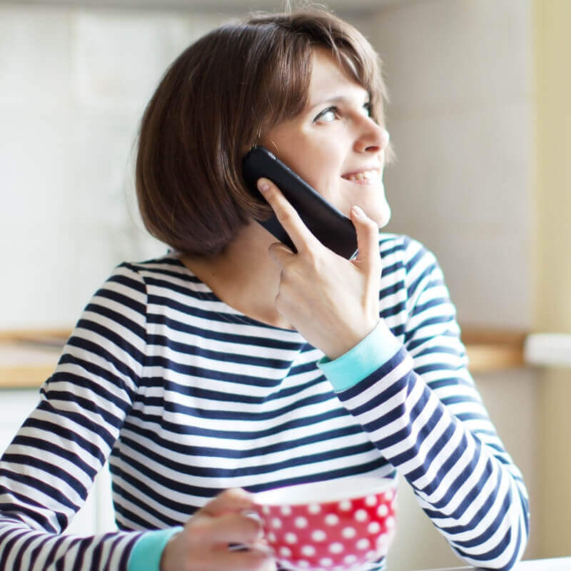 kvinna i randig tröja som pratar i en mobiltelefon